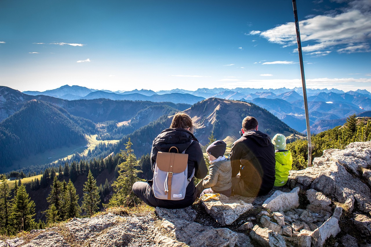 Family sitting on a mountain peak enjoying the view while planning Australian immigration