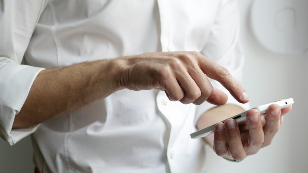 Person holding a smartphone while reading Australia visa reviews