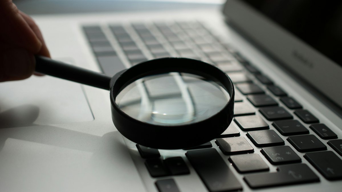 Magnifying glass next to a laptop, showing how to read reviews carefully