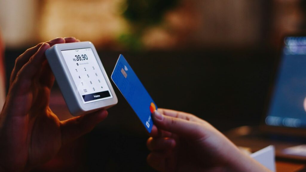 Person holding a credit card and phone, thinking about questions to ask before you pay